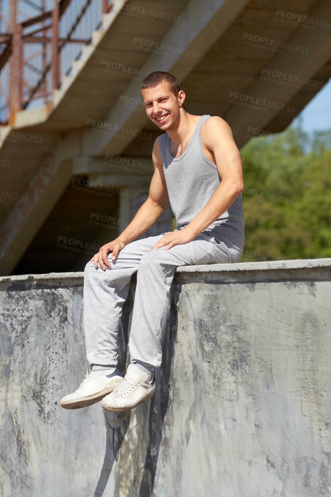 Buy stock photo A young man in sportswear sitting on a graffiti-filled wall