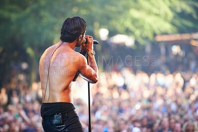 Buy stock photo Singer, man and performance at music concert, festival or party with crowd of people. Rock, celebration and musician on stage for show, talent or back of artist on microphone outdoor for social event