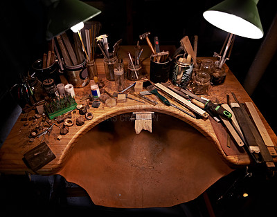 Buy stock photo Woodworking, tools and table in workshop for artist in sculpture to start project at night. Dark, studio and creative workspace for carpenter with equipment on desk for process and production