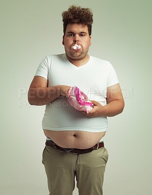 Buy stock photo Food, portrait and plus size man with marshmallow, dessert and candy in a studio. Bag, sweet and unhealthy snack for over eating a treat with funny face and hungry male person with grey background