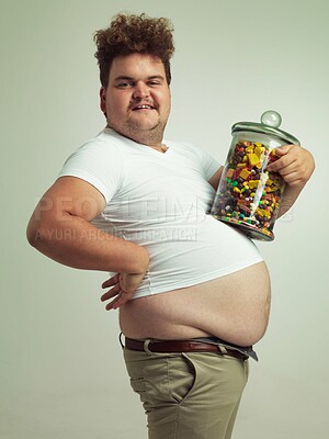 Buy stock photo Candy, jar and portrait of man in studio for luxury snacks, sweets and dessert in container. Comic, funny and food, isolated and plus size person with glass for unhealthy diet on background.