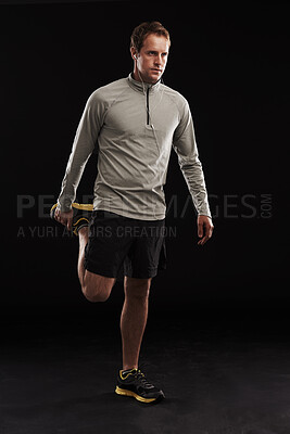 Buy stock photo Man, legs and stretching training in studio for muscle mobility or exercise workout, flexibility or black background. Male person, earphones and wellness athlete for practice, streaming or mockup