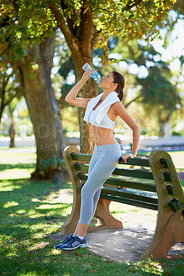 Buy stock photo Young woman, runner or drinking water in nature for training exercise, sunshine or wellness in summer. Athlete, towel or health drink in bottle for hydration, fitness or workout performance by trees