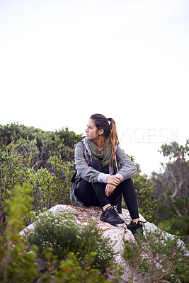 Buy stock photo Woman, sitting and rock for hiking and adventure in nature with sneakers for walking outdoor and break. Young person or hiker and look for view in landscape with bush and plants for exercise and rest