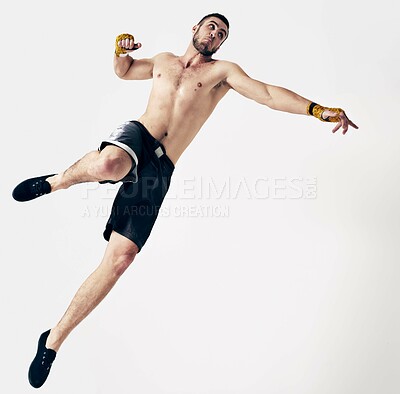 Buy stock photo Martial arts, training and man with punch in studio for exercise, workout or skill development with white background. Sport, athlete and male person for challenge, muay thai jump or competition fight