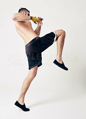 Buy stock photo Martial arts, training and man with knee kick in studio for exercise, workout or skill development with white background. Sports, athlete and male person for challenge, muay thai or competition fight
