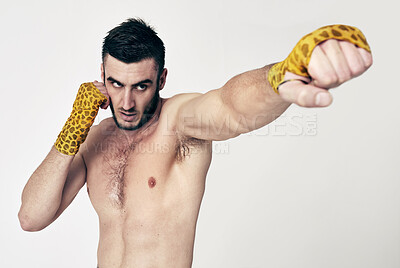 Buy stock photo Man, fight swing and punch for martial arts, self defense and exercise for physical strength and training in studio. Angry male fighter, glove bandage and tattoo for combat and recreation sport