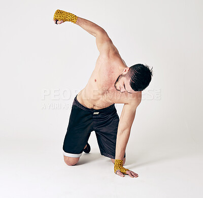 Buy stock photo Man, MMA and fighter by boxing in studio for fitness, training and workout to win every battle. Strong, kickboxing and male athlete is kneeling with gloves for self defense action against enemy