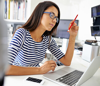 Buy stock photo Shot of a beautiful young woman using her laptop in her home office