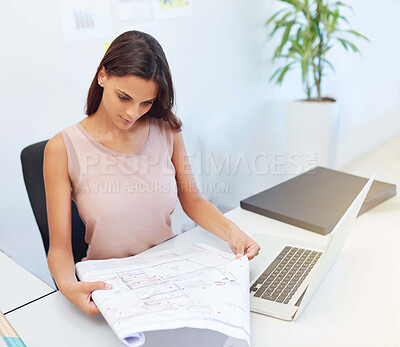 Buy stock photo Cropped shot of a young architect looking over some building plans