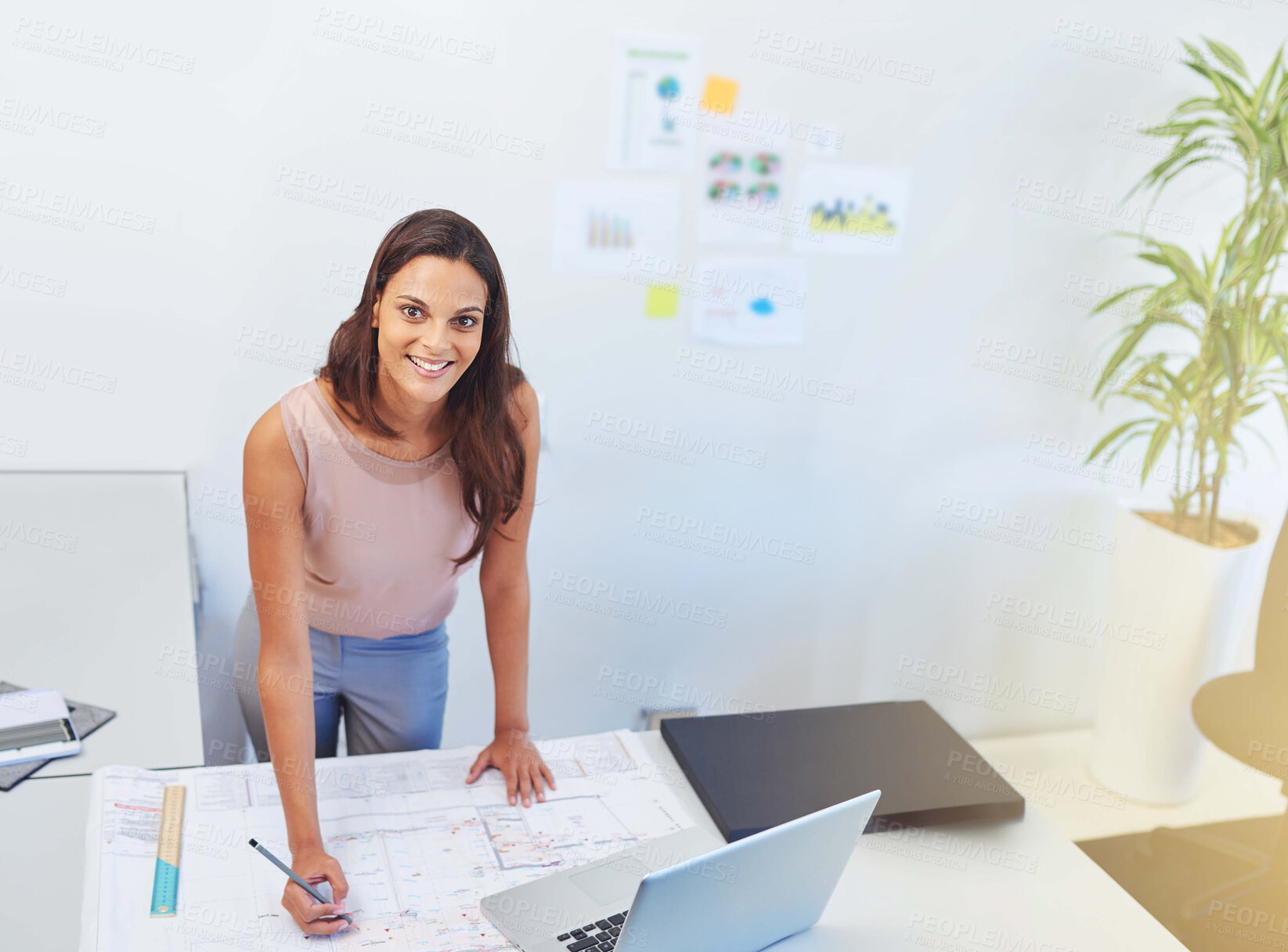 Buy stock photo Cropped portrait of a young architect looking over some building plans