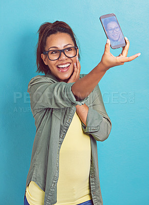 Buy stock photo Happy woman, nerd and photography with selfie in fashion for picture, memory or review on a blue studio background. Young female person, model or geek with smile or glasses for social media or moment