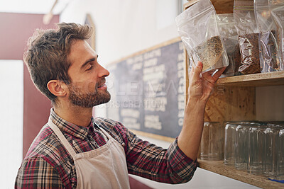 Buy stock photo Man, waiter and check by shelf in a coffee shop with idea for service, search or ingredients for drink. Barista, person or small business owner in a cafe with product, beans and thinking for decision