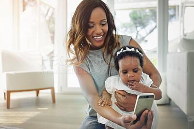 Buy stock photo Shot of a mother talking selfies with her baby daughter at home