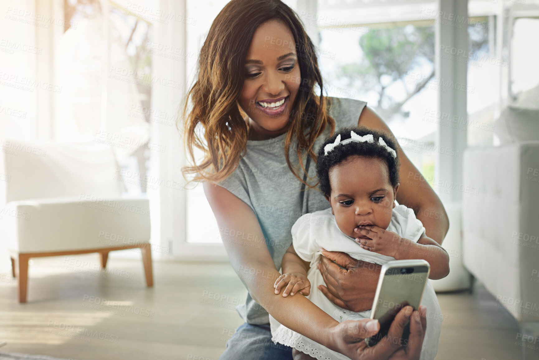 Buy stock photo Shot of a mother talking selfies with her baby daughter at home