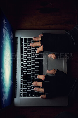 Buy stock photo High angle shot of an unidentifiable man using a laptop late at night