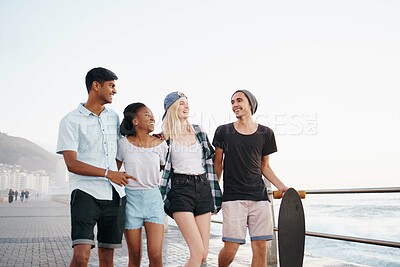 Buy stock photo Group, friends and smile for walk on promenade by ocean for diversity, bonding and talking on holiday. Men, women or gen z people with conversation, happy and outdoor on boardwalk by sea on vacation