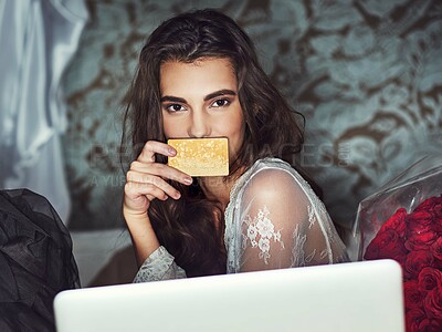 Buy stock photo Portait of a beautiful young woman browsing on her laptop while holding her credit card over her mouth