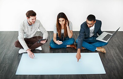Buy stock photo Studio shot of a group of young people sitting on the floor and working on blank paper