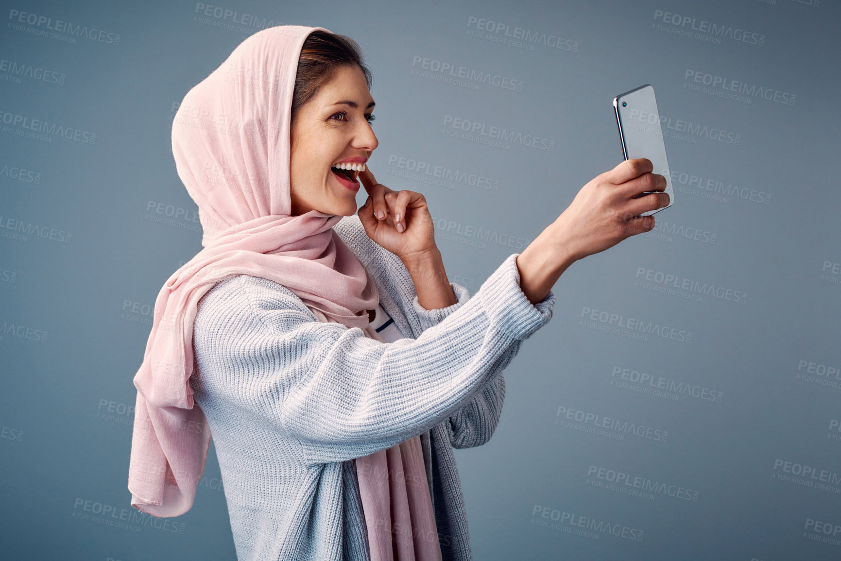 Buy stock photo Islamic woman, selfie and influencer with smile, happiness and social media on grey studio background. Muslim person, model and girl with smartphone, content creation for culture, hijab and tradition