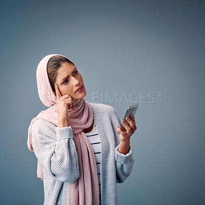 Buy stock photo Confused, muslim woman and smartphone, thinking with mockup or advertising space on dark background. Islamic, female model and hijab with technology, ideas and vision for marketing on social media