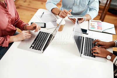 Buy stock photo Cropped shot of an unrecognizable group of businesspeople sitting together and using technology during a meeting in the office