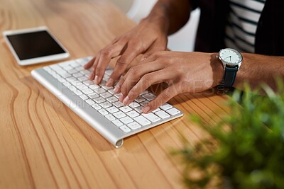 Buy stock photo Cropped shot of an unrecognizable businessman sitting alone in his office and typing on his wireless keyboard