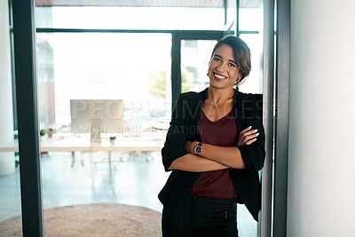 Buy stock photo Cropped portrait of an attractive young businesswoman standing alone with her arms folded in the office