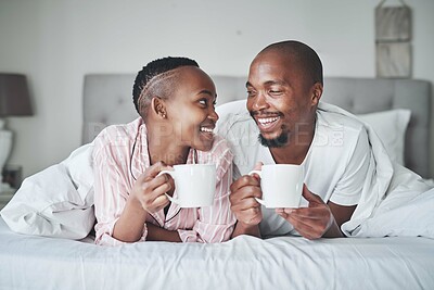 Buy stock photo Coffee, bed and morning with a black couple together in the bedroom of their home to relax on the weekend. Love, tea or early with young man and woman relaxing while bonding in their house