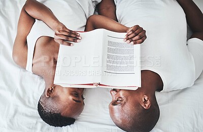 Buy stock photo Book, reading and overhead with a black couple in bed, lying together in the morning in their home. Read, books or love with a man and woman bonding in the bedroom of their house from above