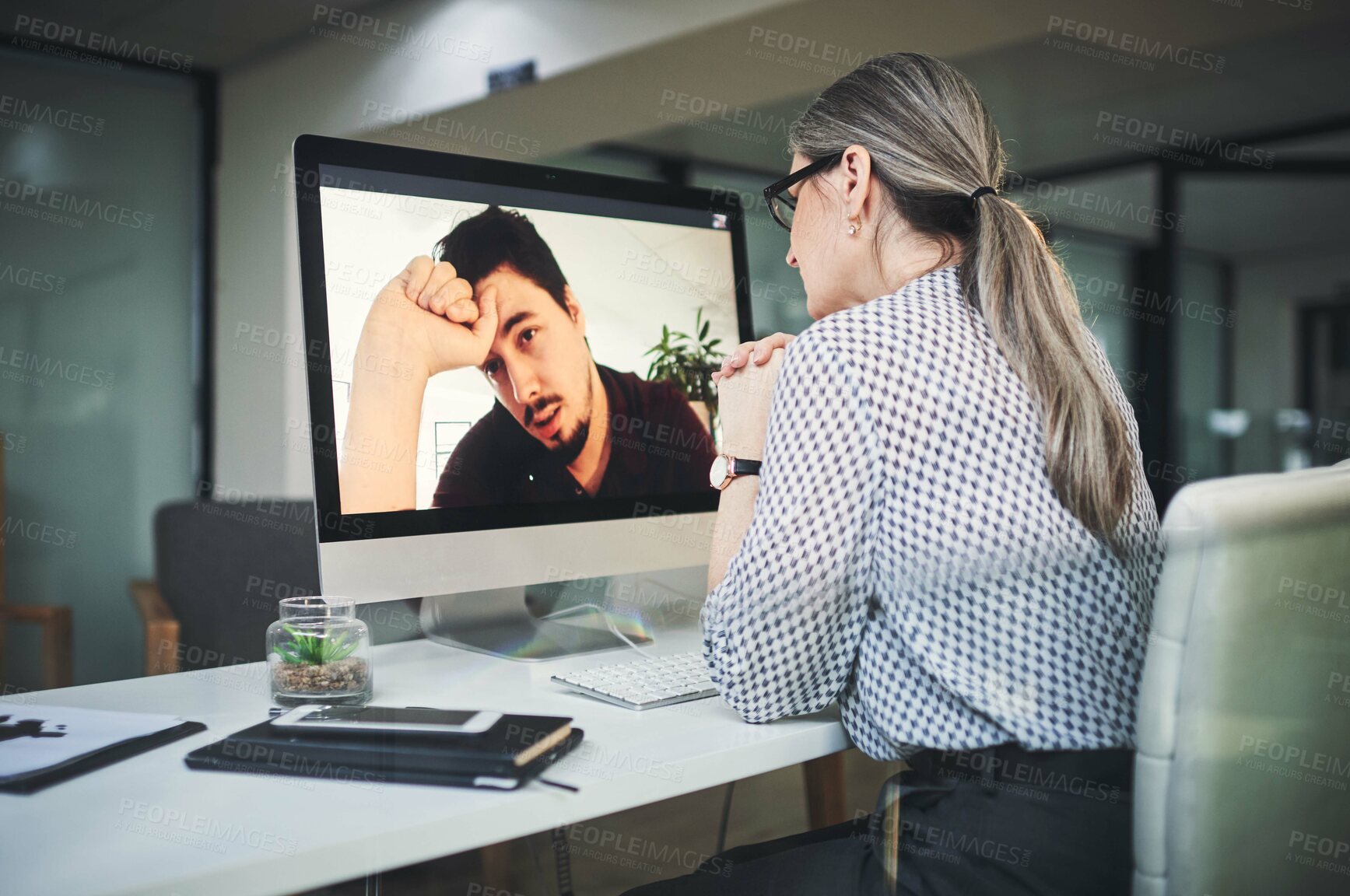 Buy stock photo Shot of a mature psychologist conducting an online therapy session with her patient