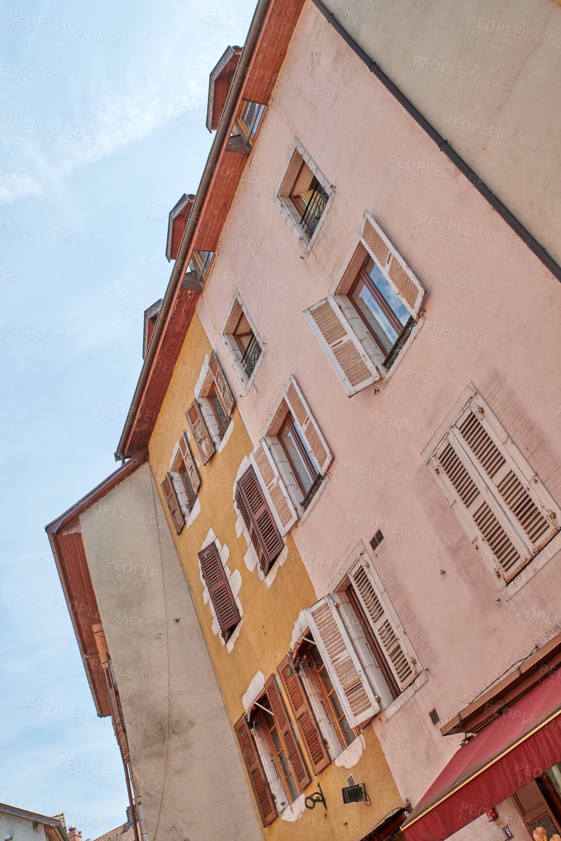 Buy stock photo Old buildings and medieval architecture in a colorful historic city from below with a clear blue sky in Annecy, France. Beautiful landscape of a small and empty urban town with homes or houses