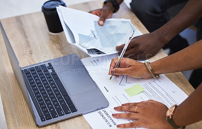 Buy stock photo High angle shot of two unrecognisable businesspeople going through paperwork and using a laptop in an office