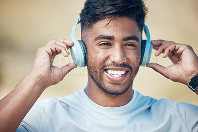 Buy stock photo Face, fitness and music with runner Indian man outdoor for cardio training, health or wellness. Exercise, headphones and smile with confident athlete running in nature for physical improvement