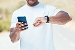 Closeup of Fit man timing himself during his run outdoors. Ethnic man checking his smartwatch while exercising outside