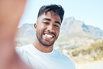 Portrait of a mixed race male taking a selfie and smiling during a workout outside in nature. Indian fit male taking a photo of himself looking happy outside
