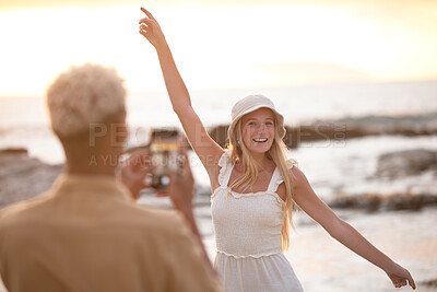 Buy stock photo Happy woman, photographer and beach with picture for memory, moment or outdoor model in sunset. Female person with smile in summer fashion for photography, capture or vlog by ocean coast in nature