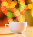 Closeup of a cup isolated against a vibrant bokeh background. One white teacup on a table. Crockery used to enjoy a warm beverage from such as tea or coffee in a cafe or at home