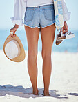 Rearview beautiful young caucasian woman relaxing on the beach. Enjoying a summer vacation or holiday outdoors during summer. Taking time off and getting away from it all. Spending the day alone