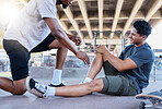 Sports injury, knee and skater man holding wound after accident, falling and fail on skateboard at urban community skate park. Male friends, skating and helping with sore leg during training