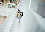 Top view, woman and walking in library, college and education for knowledge, intelligence and smart. Female, student and girl with backpack, university and bookshelf for test, casual or trendy person