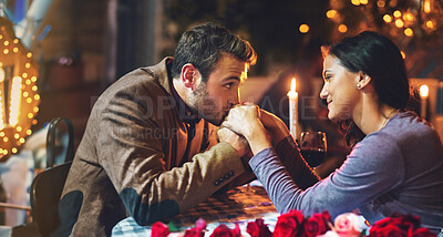 Buy stock photo Couple, dinner and date in restaurant for romance with hand kiss, candle or commitment to relationship at night. Man, woman and anniversary celebration on valentines day with happiness or fine dining