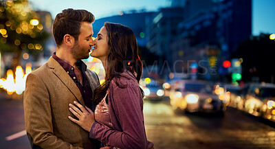 Buy stock photo Couple, night and kiss in city for love, nose touch and bonding for romance and sweet moment. Happy, affection and people in commitment and trust, security and support together with time together