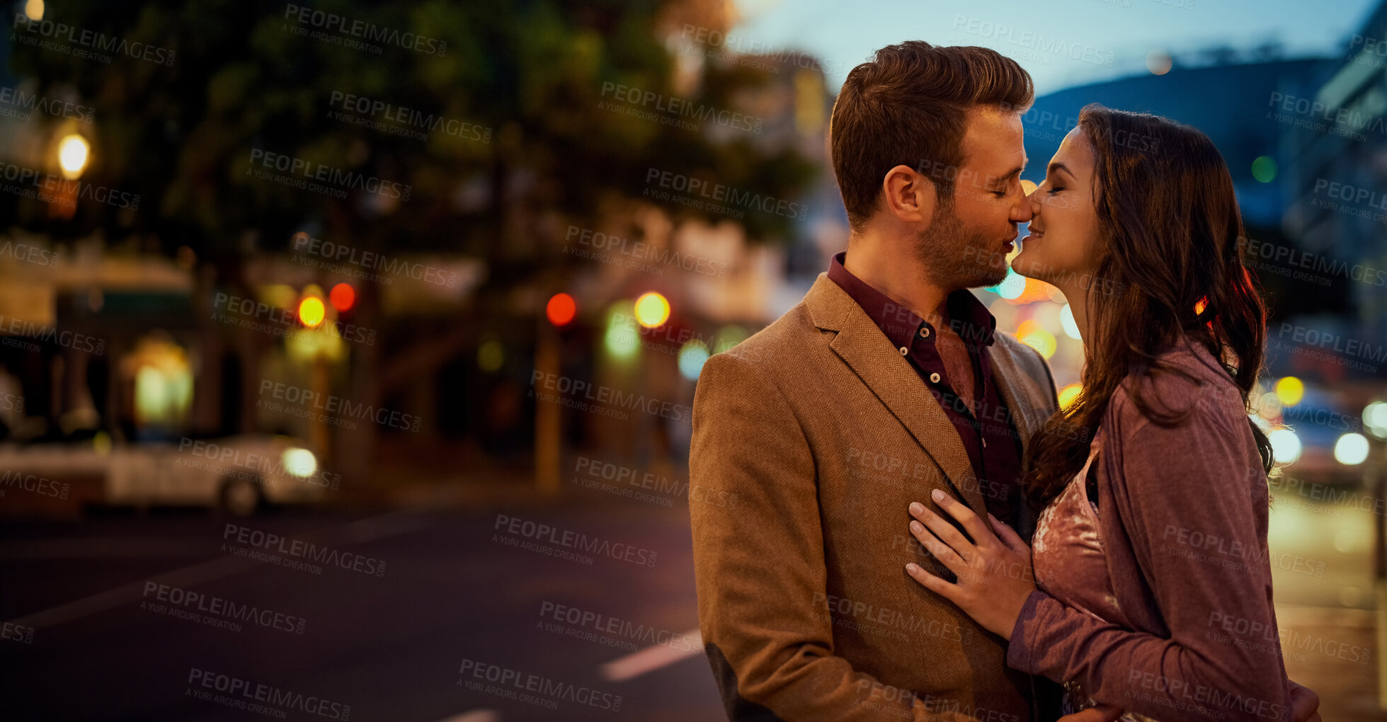 Buy stock photo Couple, night and city with hug and kiss on date, romance and bonding with love in relationship. Happiness, affection and people with commitment and trust, sweet moment and romantic together outdoor