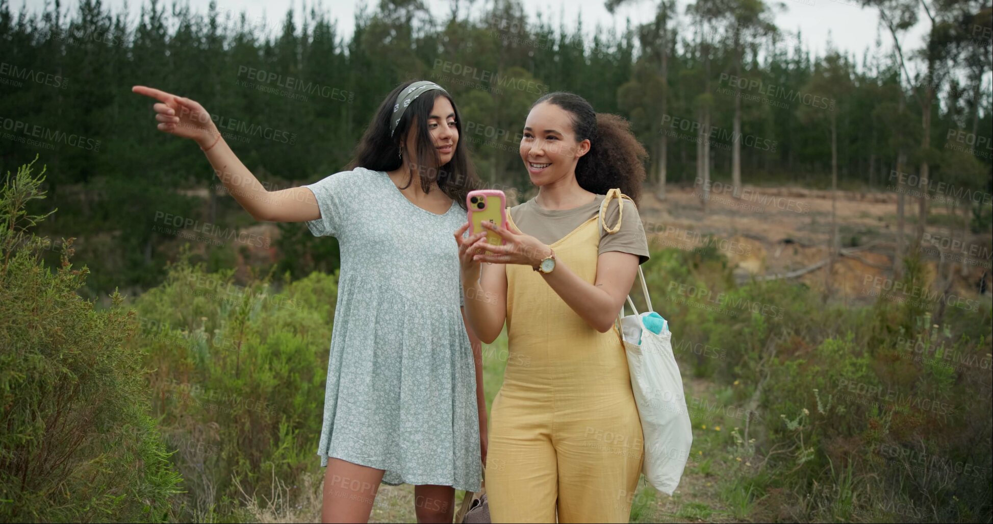 Buy stock photo Happy woman, friends and phone in forest for social media, photography or pointing for natural outdoor scenery. Female person or people smile with mobile smartphone in nature or woods with trees