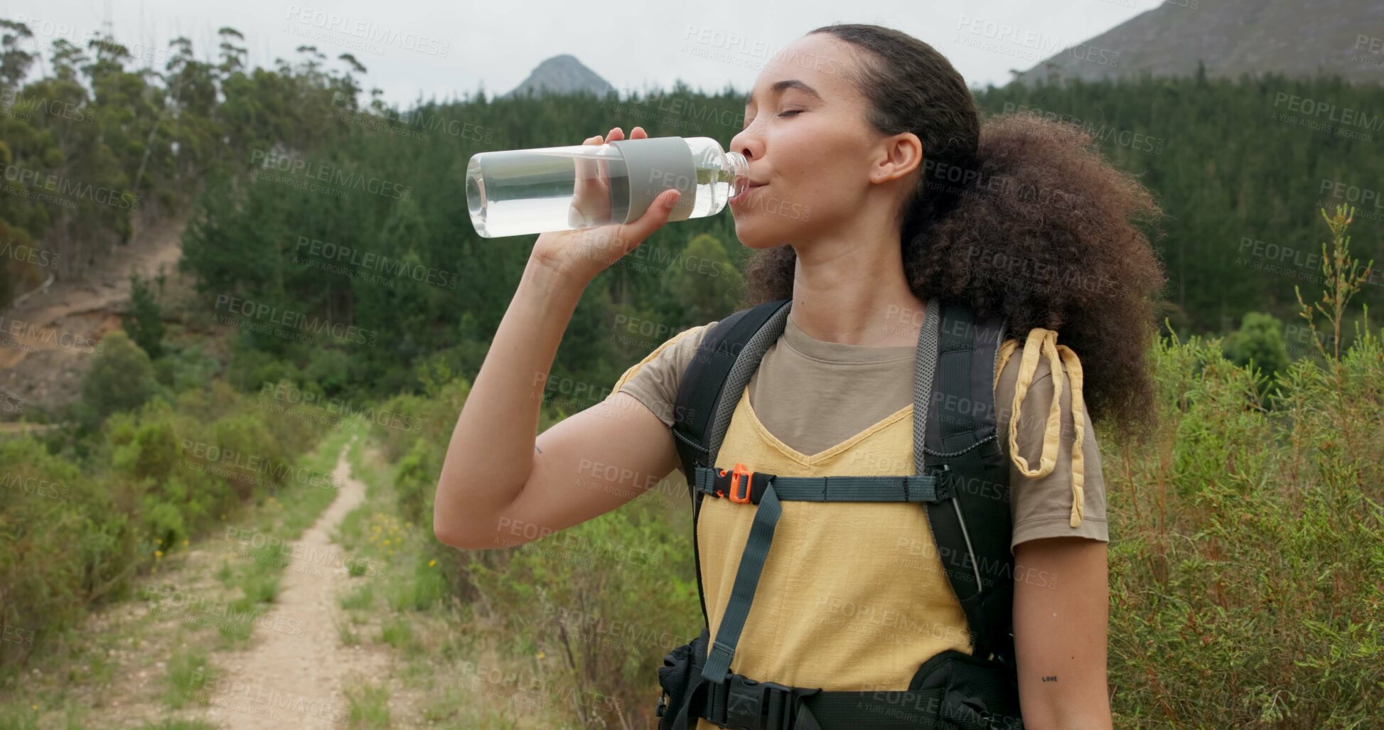 Buy stock photo Hiking woman, drinking water and bottle in nature for hydration, detox or wellness on bush adventure. Girl, trekking and liquid for health in forest, woods and outdoor for fitness, exercise or summer