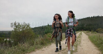 Friends, women walk and talk while hiking in nature, travel together for bonding and fun. Adventure, journey and trekking, sightseeing in forest or park for tourism, environment and backpacking