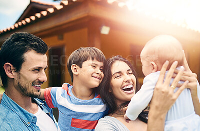 Buy stock photo Cropped shot of a happy young family of four outside with their house in the background