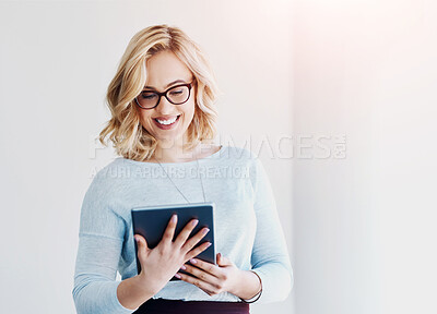 Buy stock photo Shot of an attractive young businesswoman using a digital tablet in an office