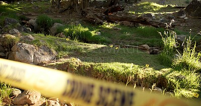 Crime scene, outdoor and forest for investigation, police and forensic background with yellow tape and lens flare. Security, inspection and search for clues or sample in woods or nature by rocks